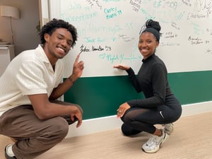 Zekai '23 and Nylah Hamilton '15 sign the alumni wall